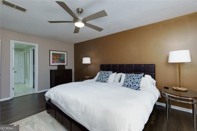 bedroom featuring wood finished floors, baseboards, and a ceiling fan