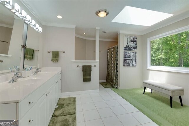 bathroom with crown molding, double vanity, tile patterned floors, a skylight, and recessed lighting