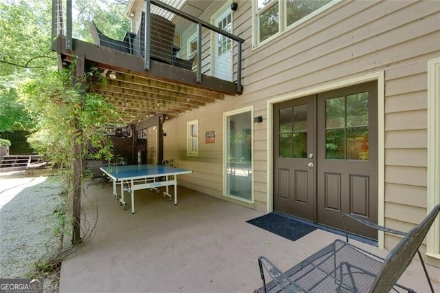 entrance to property with a patio area, fence, and french doors