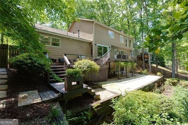rear view of property with stairway, a patio area, fence, and a wooden deck