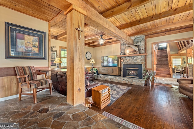259 Eagle Chase Cir, Dillard, GA 30537 - living area featuring wood ceiling, a stone fireplace, beamed ceiling, a ceiling fan, and a wainscoted wall