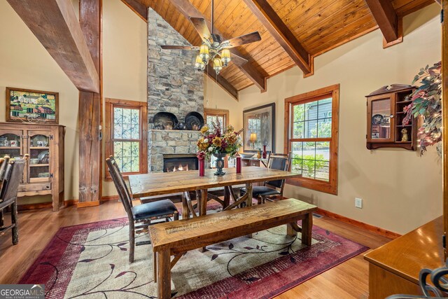 259 Eagle Chase Cir, Dillard, GA 30537 - dining space featuring a stone fireplace, ceiling fan, wood finished floors, beam ceiling, and baseboards
