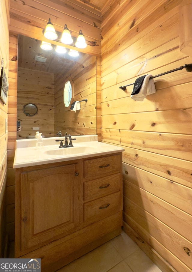 bathroom with wood walls, vanity, and tile patterned flooring