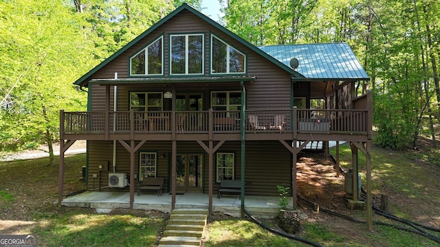 back of house featuring faux log siding, a patio, and a wooden deck