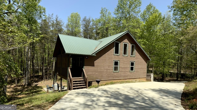 view of front of home featuring metal roof and log veneer siding