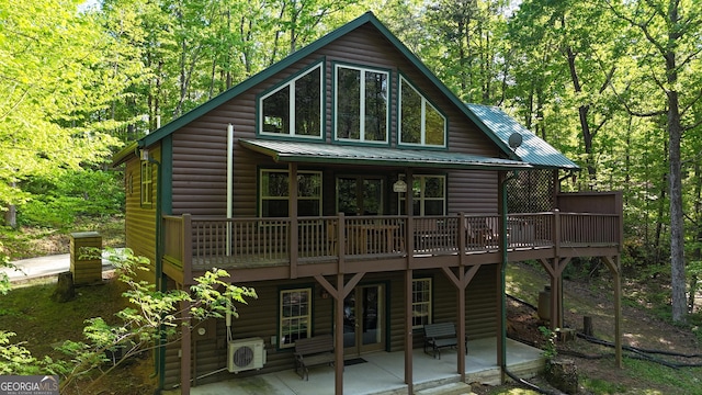 rear view of house featuring faux log siding, a patio area, french doors, a deck, and ac unit