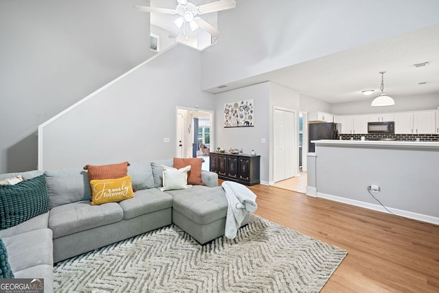 4104 Glenaire Way NW, Acworth, GA 30101 - living room featuring light wood finished floors, ceiling fan, and a towering ceiling
