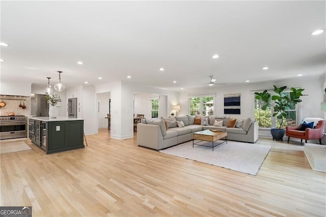 living room featuring light wood-style floors, recessed lighting, a ceiling fan, and baseboards