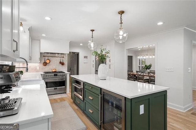 kitchen with green cabinetry, high end stainless steel range, beverage cooler, light countertops, and recessed lighting