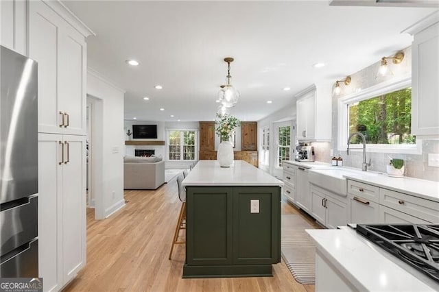 kitchen with freestanding refrigerator, backsplash, open floor plan, white cabinetry, and recessed lighting