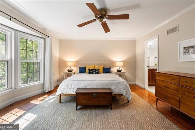 bedroom featuring light wood-style floors, crown molding, baseboards, connected bathroom, and ceiling fan