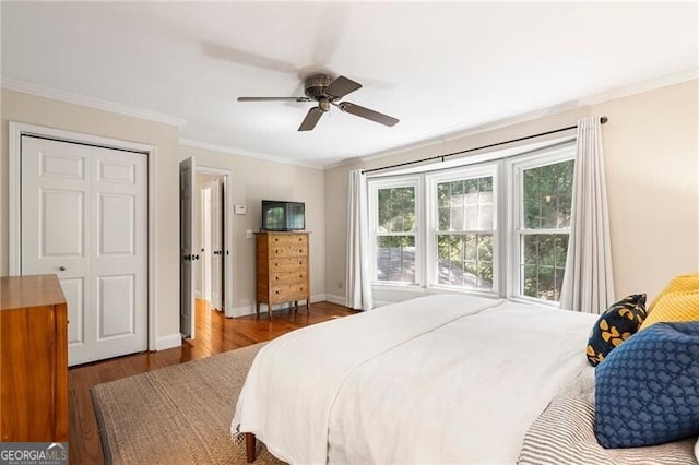 bedroom with wood finished floors, ornamental molding, baseboards, and a ceiling fan