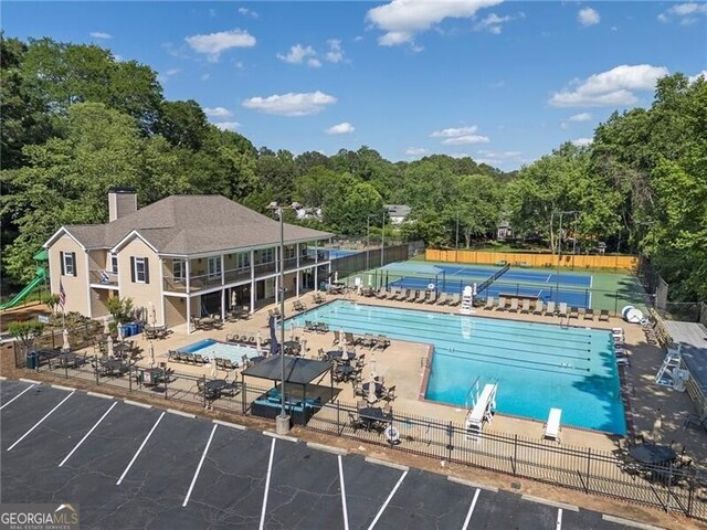 community pool with fence and a patio area
