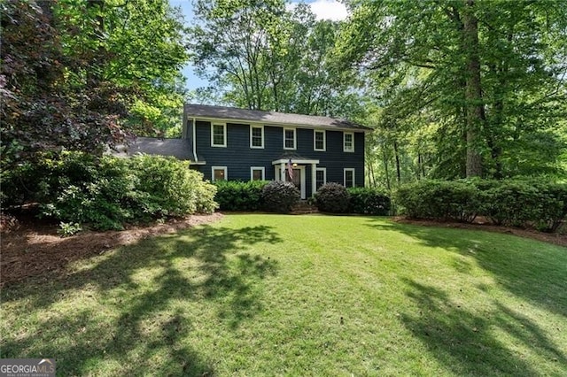 colonial-style house featuring a front lawn