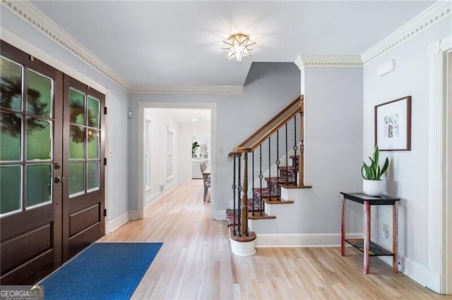 entryway featuring french doors, stairs, wood finished floors, baseboards, and ornamental molding