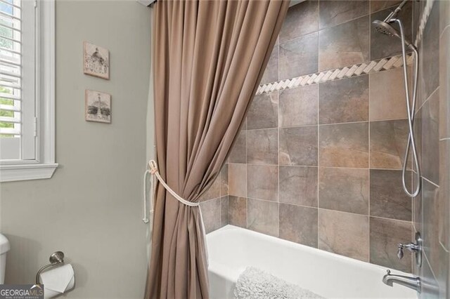 full bathroom with shower / bathtub combination with curtain and toilet
