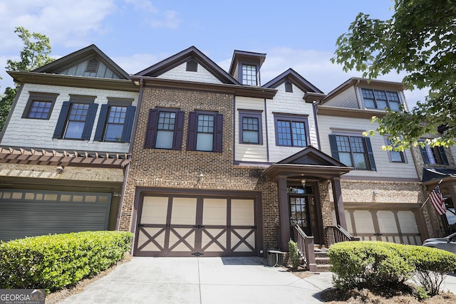townhome / multi-family property with driveway, a garage, and brick siding
