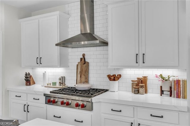 6150 Bridge Fair Rd, Cumming, GA 30028 - kitchen with wall chimney exhaust hood, stainless steel gas stovetop, white cabinets, tasteful backsplash, and light stone countertops