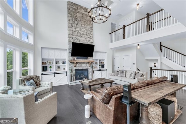 6150 Bridge Fair Rd, Cumming, GA 30028 - living area featuring a towering ceiling, a stone fireplace, dark wood-style flooring, and a chandelier