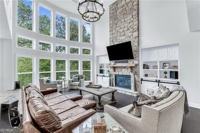 6150 Bridge Fair Rd, Cumming, GA 30028 - living room featuring a high ceiling, a fireplace, a chandelier, wood finished floors, and baseboards