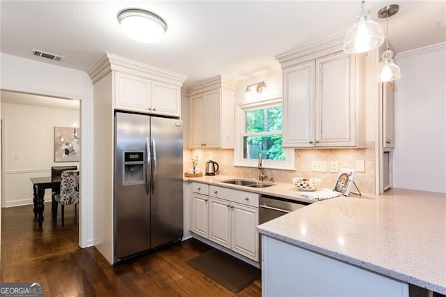 kitchen featuring stainless steel refrigerator with ice dispenser, a sink, tasteful backsplash, light stone counters, and a peninsula