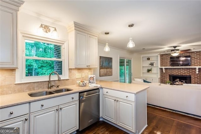 kitchen featuring dishwasher, a sink, open floor plan, a ceiling fan, and a peninsula