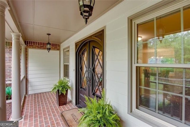 view of exterior entry featuring covered porch