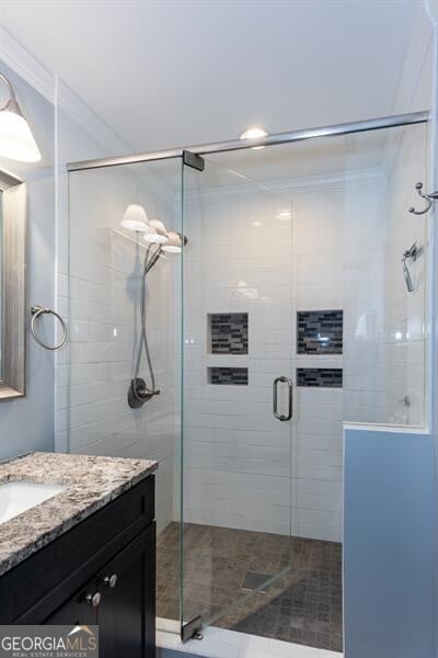 bathroom with vanity, ornamental molding, a shower stall, and recessed lighting
