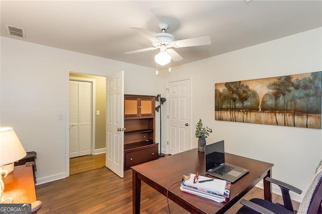 home office featuring wood finished floors, ceiling fan, and baseboards