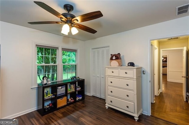 bedroom featuring dark wood-style floors, baseboards, a closet, and ceiling fan