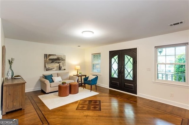 foyer entrance featuring wood finished floors, baseboards, and french doors