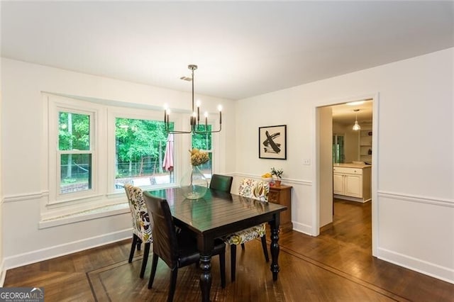 dining area featuring a chandelier, baseboards, and dark wood-type flooring