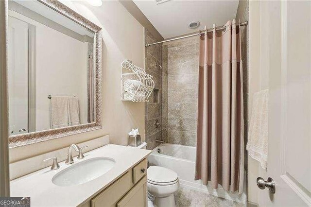 bathroom featuring shower / tub combo with curtain, toilet, and vanity