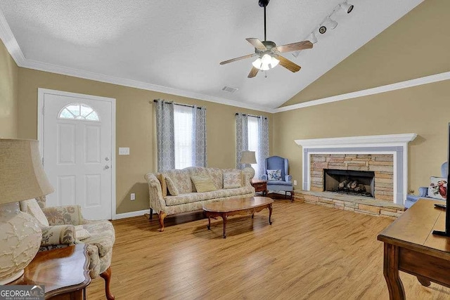 living room featuring plenty of natural light, light wood finished floors, a ceiling fan, baseboards, and lofted ceiling