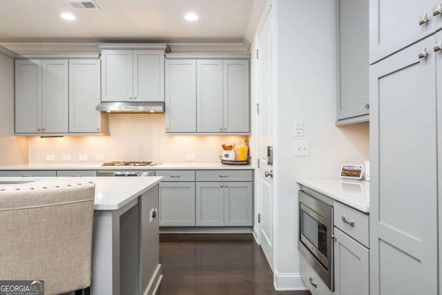 kitchen with stainless steel appliances, under cabinet range hood, light countertops, gray cabinets, and recessed lighting