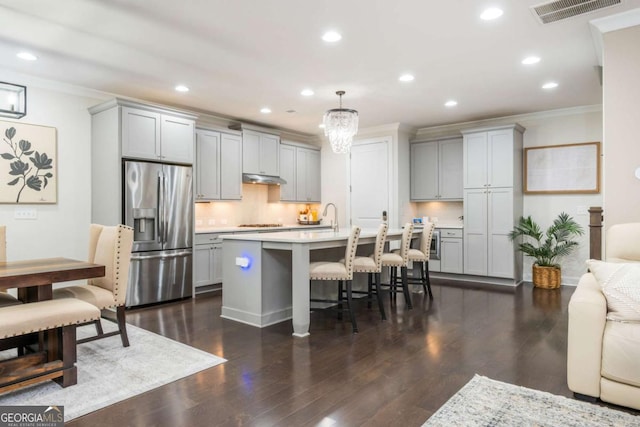kitchen featuring stainless steel fridge with ice dispenser, gray cabinets, crown molding, light countertops, and under cabinet range hood