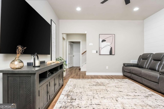 living area featuring light wood-style floors, a ceiling fan, stairs, recessed lighting, and baseboards