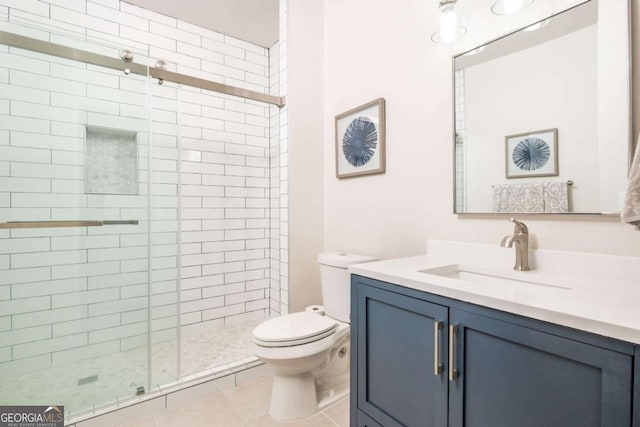 bathroom with a stall shower, toilet, vanity, and tile patterned flooring