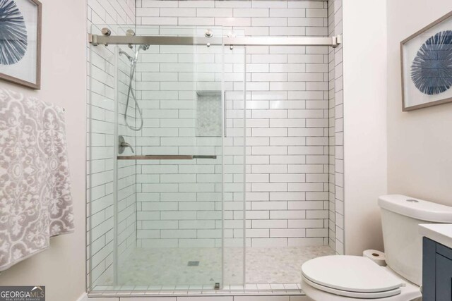 full bath with toilet, a stall shower, and vanity