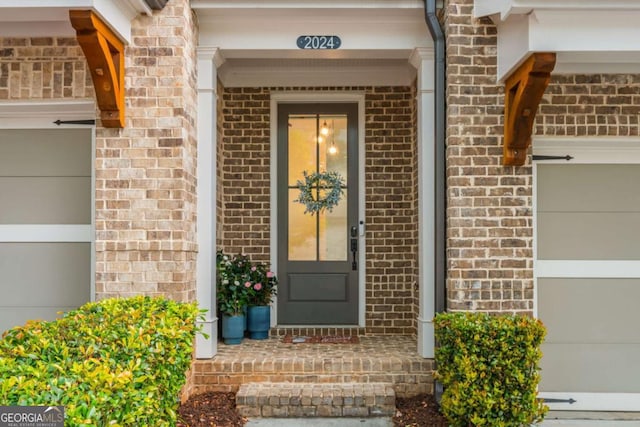 entrance to property featuring brick siding and an attached garage