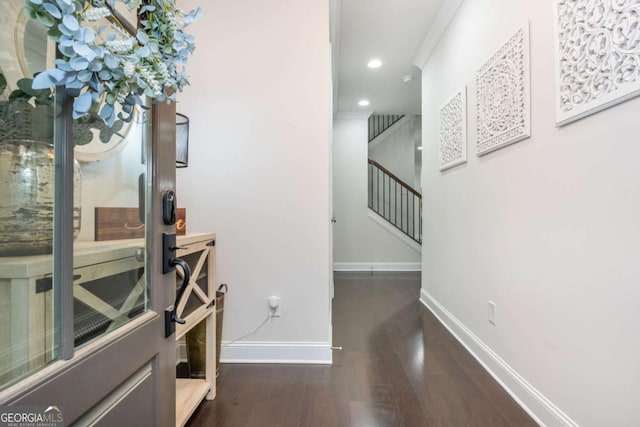 corridor with baseboards, wood finished floors, stairs, and recessed lighting
