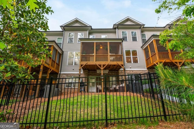 back of property featuring a sunroom and brick siding