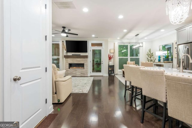living room with a fireplace, recessed lighting, dark wood finished floors, a chandelier, and ceiling fan