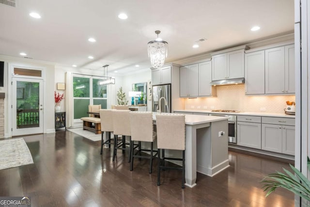 kitchen with gray cabinets, light countertops, recessed lighting, a kitchen island with sink, and decorative backsplash