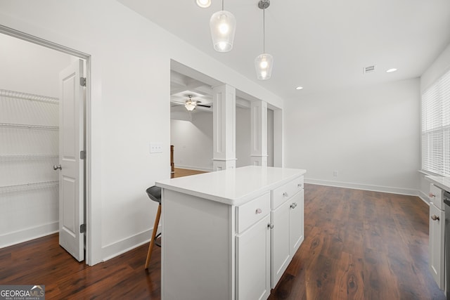 kitchen featuring white cabinetry, light countertops, dark wood finished floors, a center island, and hanging light fixtures