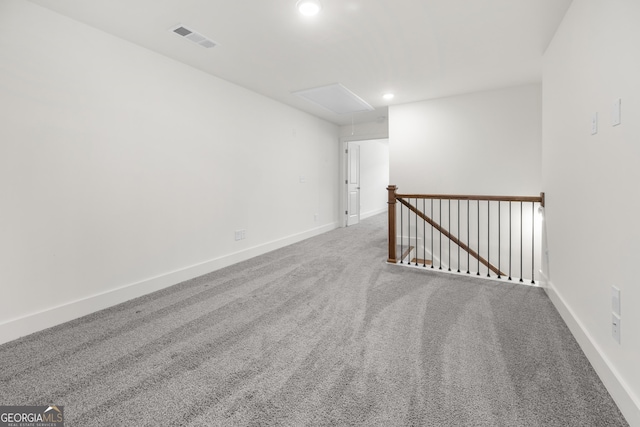 spare room featuring attic access, baseboards, carpet, and recessed lighting