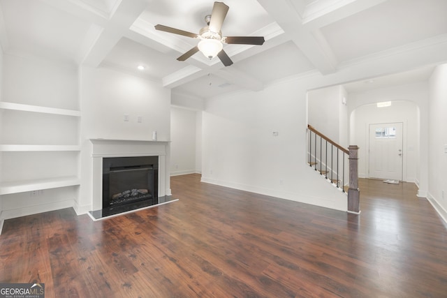unfurnished living room featuring arched walkways, coffered ceiling, stairway, ceiling fan, and a fireplace with raised hearth