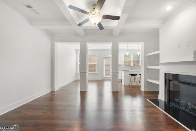 unfurnished living room featuring decorative columns, a ceiling fan, a glass covered fireplace, coffered ceiling, and beam ceiling
