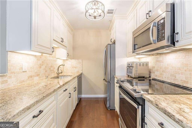 28106 Plantation Dr NE, Atlanta, GA 30324 - kitchen featuring stainless steel appliances, a sink, backsplash, and light stone counters