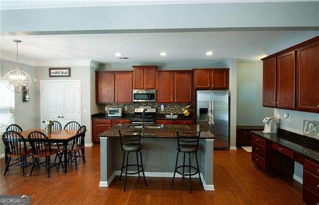 4271 Haywater Cv, Buford, GA 30519 - kitchen featuring stainless steel appliances, a chandelier, a breakfast bar, dark wood finished floors, and ornamental molding